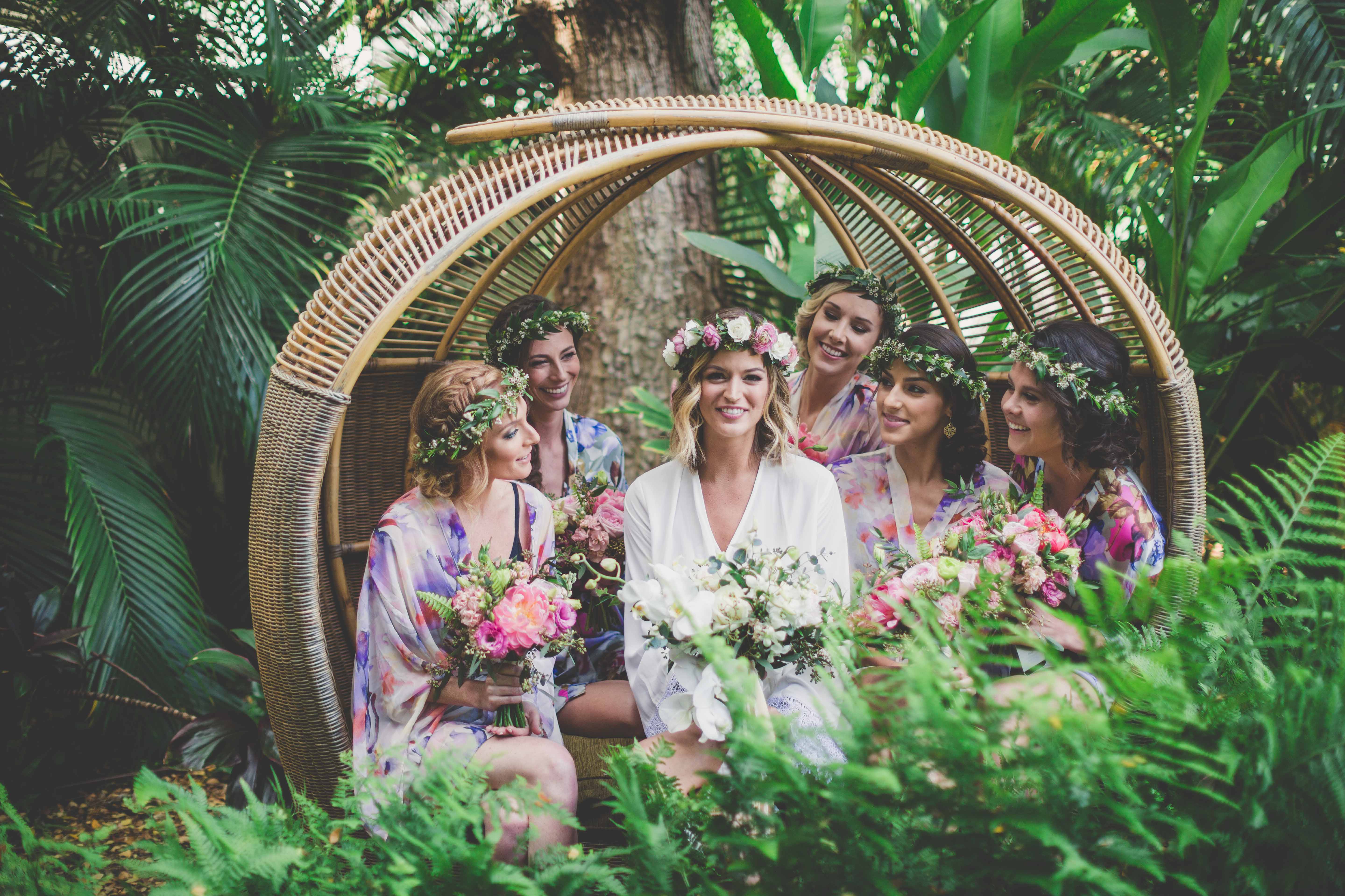 bride with bridesmaids in flower crowns in rattan circle chair